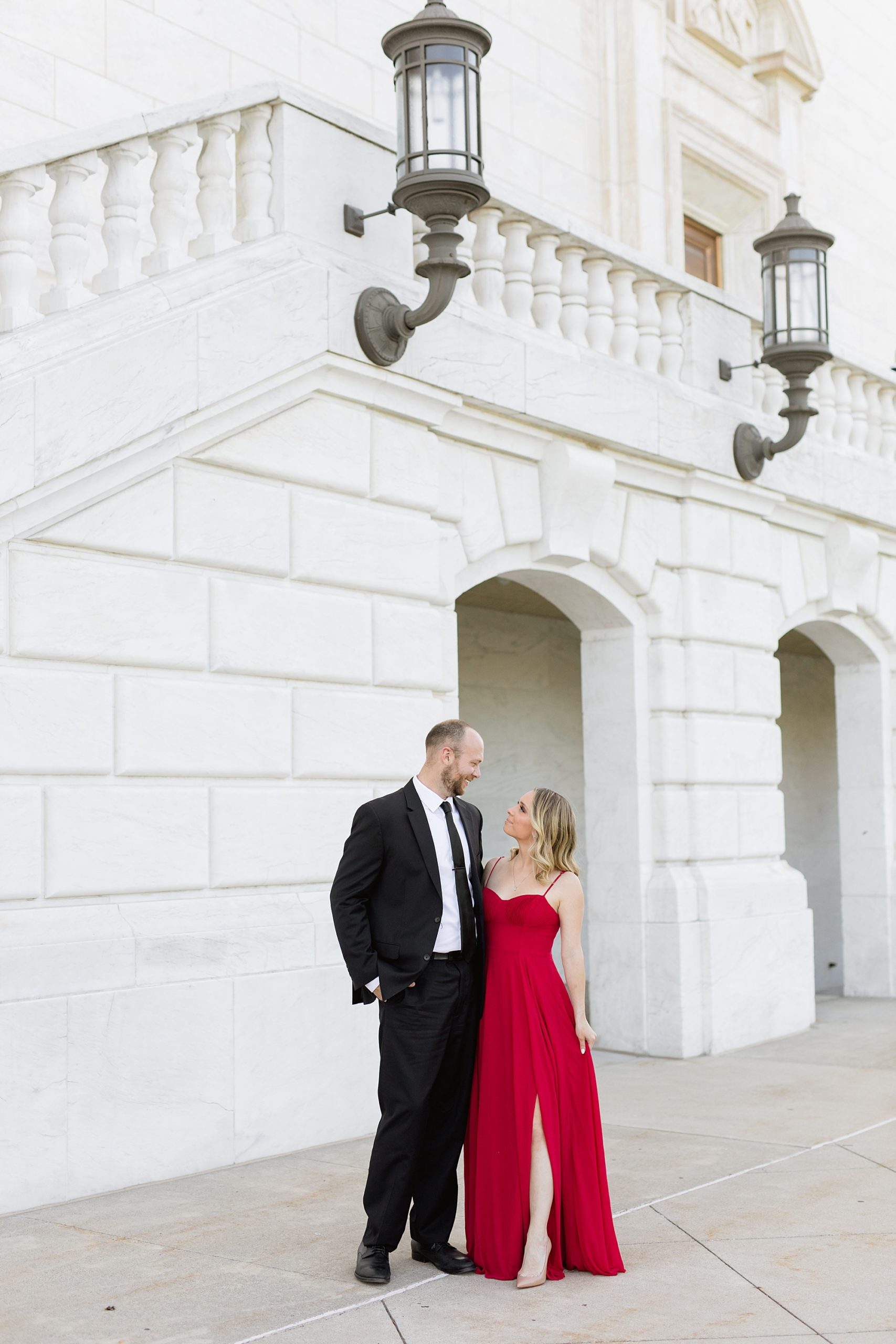 Classy engagement photos of woman in a red dress and man in a black suit